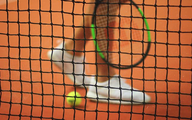 Nahaufnahme eines Tennisspielers, der über den Tennisplatz läuft